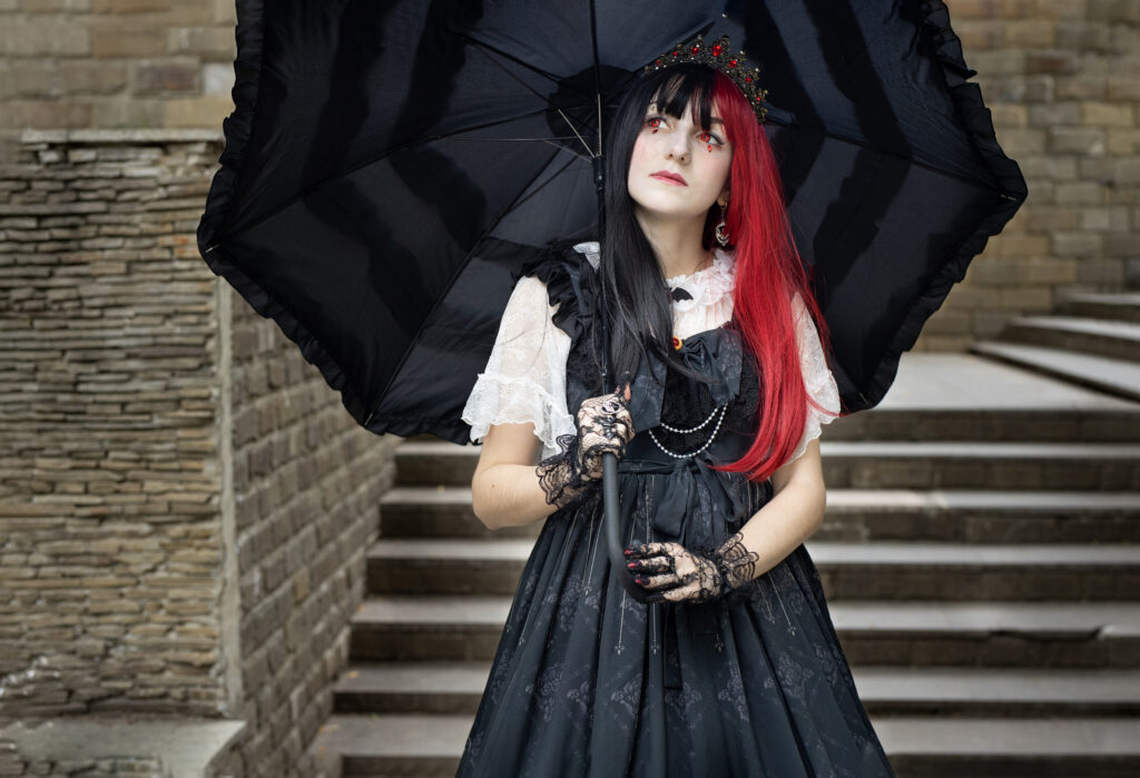 Woman dressed in gothic clothing holding a black parasol